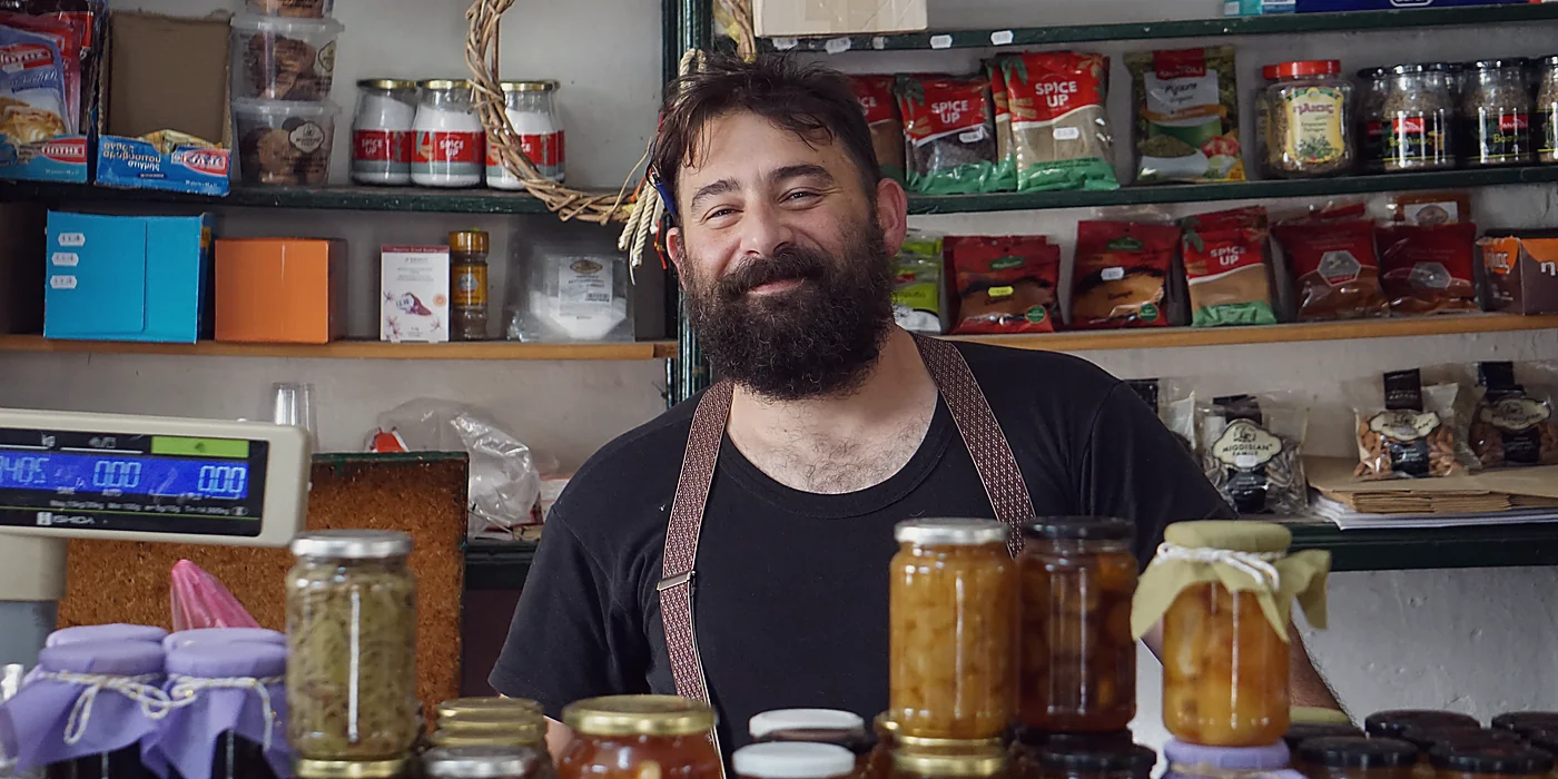 A small business owner smiling behind his shop counter, the voice a brand should capture