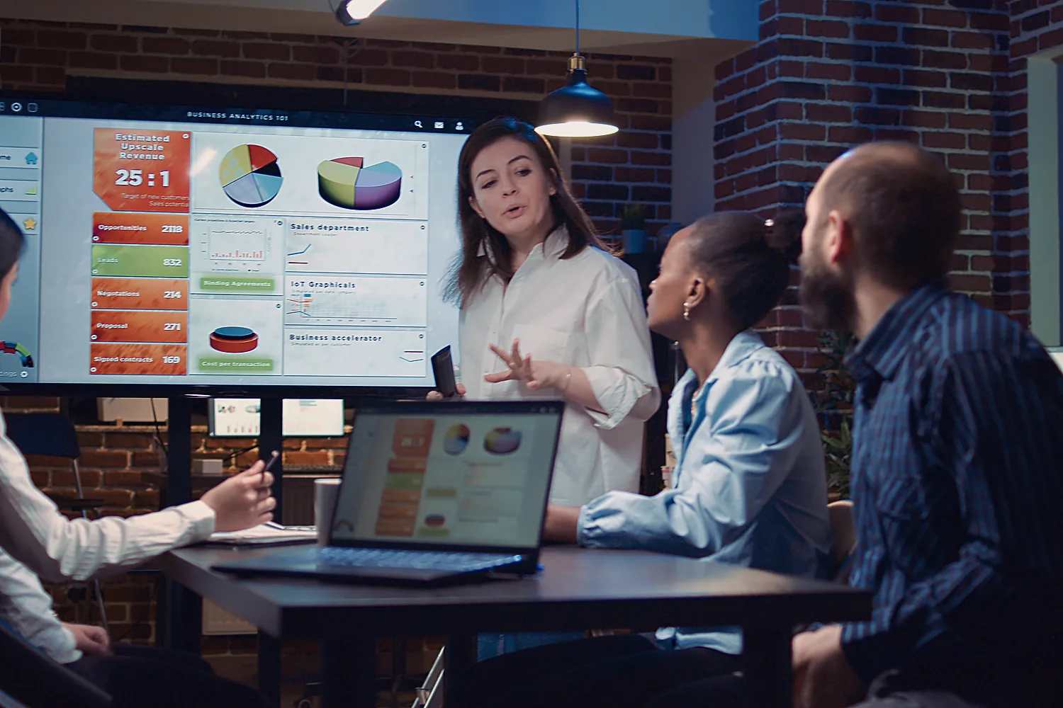 A consultant walks a small team through website analytics on a large screen